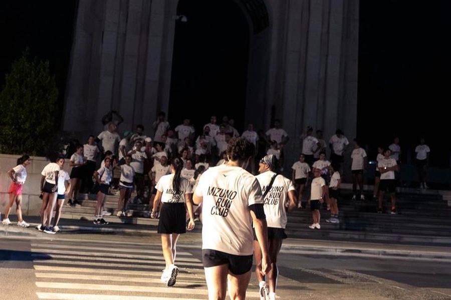 Runners crossing towards the war memorial arch in Caserta at night